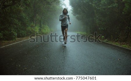 Handsome, young jogger running in the exotic area