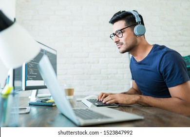 Handsome young male software developer programming codes while working from home - Shutterstock ID 1523847992