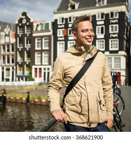 Handsome Young Man, Admiring The Beauty Of Amsterdam Center On A Bridge In A Sunny Summer Day