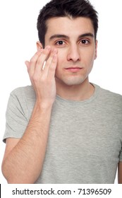 Handsome Young Man Applying Eye Cream For Dark Circles (isolated On White Background)