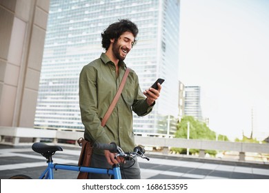 Handsome young man with beard and cycle using smartphone to read text message - Powered by Shutterstock