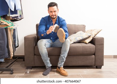 Handsome Young Man With A Beard Polishing His Shoes And Getting Dressed At Home