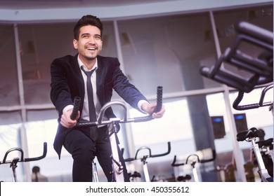 Handsome Young Man In A Black Suit, White Shirt And Tie Training In The Gym