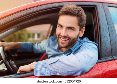 Handsome young man in a blue shirt driving a car - Powered by Shutterstock