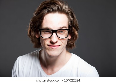 Handsome Young Man With Brown Long Hair And Retro Glasses Isolated On Grey Background. Fashion Studio Shot. Expressive Face.