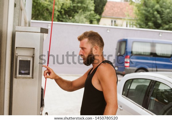 A handsome\
young man buys a token at a car\
wash