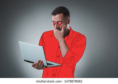 Handsome young man with a cartoon eyes and shirt is holding a laptop, looking at it and acting like he is shocked. - Powered by Shutterstock