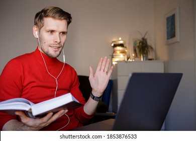 Handsome Young Man In Casual Red Clothes Reading A Book In A Video Teacher Call. Book Club Online  Social Distancing. Online Education In Video Conferencing. Virtual Bible Study. Internet Book Circle