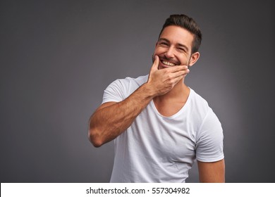 A Handsome Young Man Checking The Skin On His Face And Smiling
