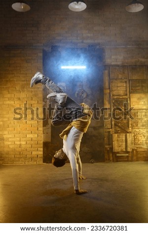 Handsome young man developing freeze over dance studio background