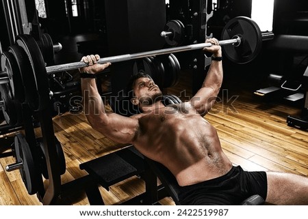 handsome young man doing bench press workout in gym, Fitness motivation, sports lifestyle, health, athletic body, body positive. Film grain, selective focus
