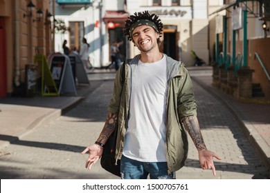 Handsome Young Man With Dreadlocks Hairstyle And Head Scarf, Gangsta Rap Singer, Rapper In City Street. Afroamerican Underground Style. Close Up Portrait Of Man Dressed Autumn Fashion Stylish Outfit