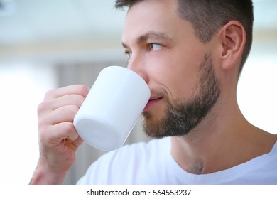 Handsome Young Man Drinking Coffee At Home, Closeup