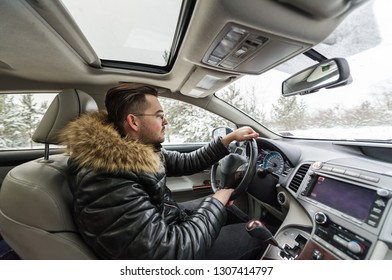 Handsome Young Man Driving In Car Through Winter Forest. Closeup Photo