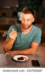 Handsome Young Man Eating Dessert In A Cafe