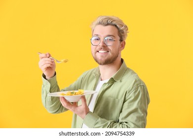 Handsome Young Man Eating Tasty Ravioli On Color Background