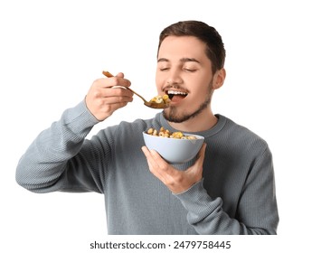 Handsome young man eating tasty cereal rings on white background - Powered by Shutterstock