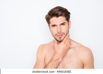 Handsome young man expertising his face before shaving