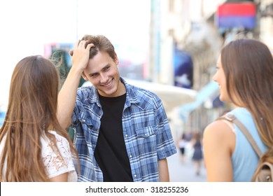 Handsome young man flirting with two girls in the street
