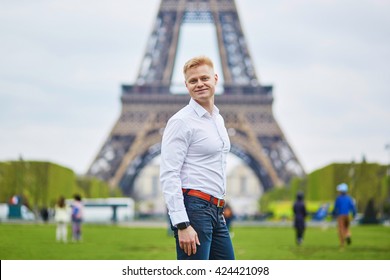 Handsome young man in front of the Eiffel tower in Paris, France