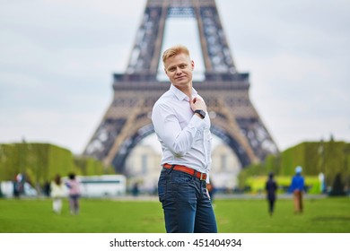 Handsome young man in front of the Eiffel tower in Paris, France