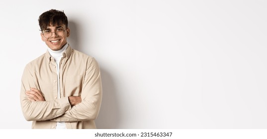 Handsome young man in glasses cross arms on chest, smiling at camera carefree, standing on white background. - Powered by Shutterstock