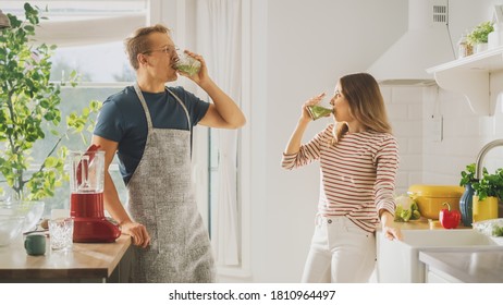 Handsome Young Man in Glasses Wearing Apron and Beautiful Girl are Making A Smoothie in the Kitchen. Happy Couple are Trying Healthy Organic Beverage. Male and Female at Home on a Sunny Day. - Powered by Shutterstock