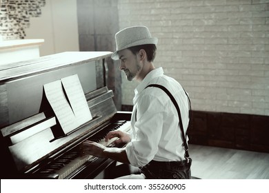 Handsome young man in hat making piano music - Powered by Shutterstock