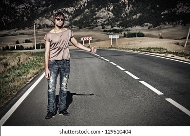 Handsome Young Man Hitchhiker Standing On A Road Over Picturesque Landscape.