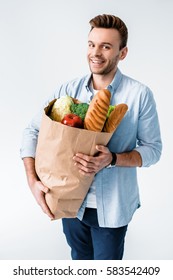 Handsome Young Man Holding Grocery Bag With Products And Smiling At Camera Isolated On White