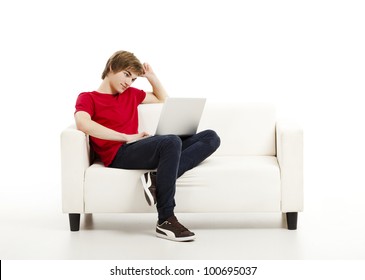 Handsome Young Man At Home Sitting On The Couch And Working On The Laptop