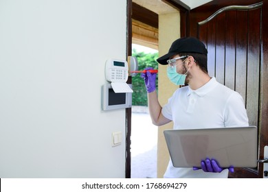 Handsome Young Man Installing Anti Burglary Alarm At A Client House With A Surgical Mask And Gloves During Pandemic Period