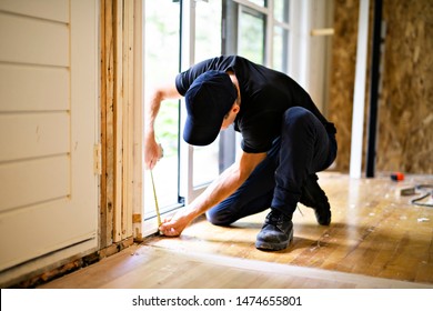 A Handsome Young Man Installing Double Sliding Patio Door In A New House Construction Site