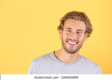 Handsome Young Man Laughing On Color Background