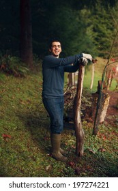 Handsome Young Man Leaning On Fence Post