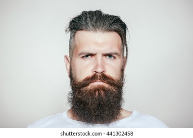 Handsome Young Man With Long Beard And Moustache On Serious Face On Grey Background In Studio