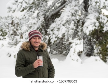 Handsome Young Man Looking At Camera And Drinking Coffee With Thermos Mug And Enjoying Snow In Winter Season. Winter In Eskisehir.