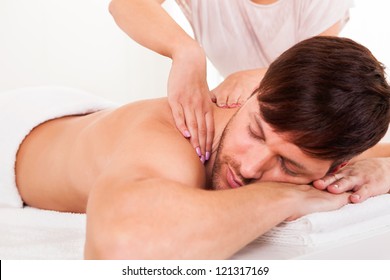 Handsome Young Man Lying On His Stomach In A Spa Having A Shoulder Massage