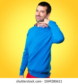 Handsome young man making phone gesture on colorful background - Shutterstock ID 1049280611