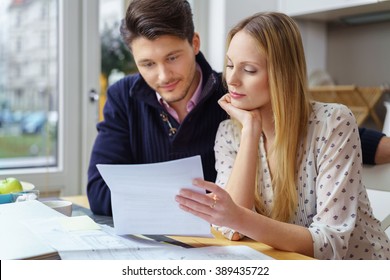 Handsome young man with mustache and beautiful woman with long hair at table looking at documents in kitchen next to window - Powered by Shutterstock - Get 15% off with code: PIKWIZARD15