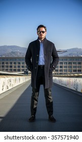 Handsome Young Man Outside Wearing Winter Coat And White Shirt, Looking At Camera, Day Shot.