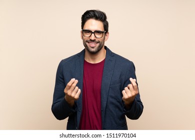 Handsome young man over isolated background making money gesture