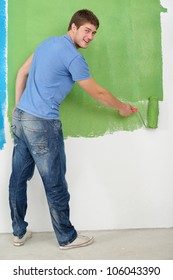 Handsome Young Man Paint In Blue And Green Color  White Wall Of New Home