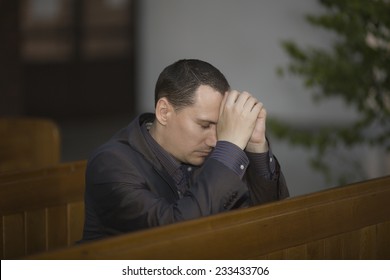 Handsome Young Man Praying In A Church