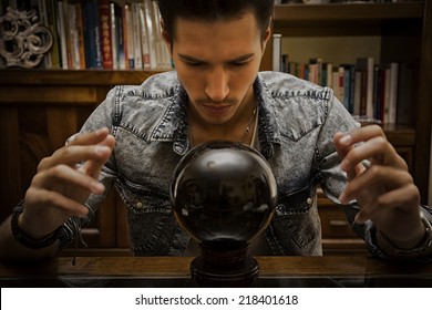 Handsome Young Man Predicting The Future By Looking Into Black Crystal Ball