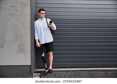 Handsome young man with a prosthetic leg using his smartphone outdoors in an urban setting - Powered by Shutterstock