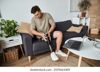 Handsome young man with prosthetic leg sits comfortably on a couch, focused on adjustment. - Powered by Shutterstock