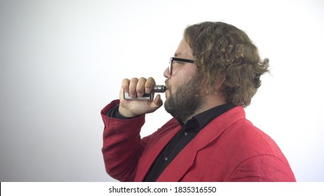 Handsome Young Man In A Red Jacket Exhales Steam From A Vape Pen Into The Camera. 4k