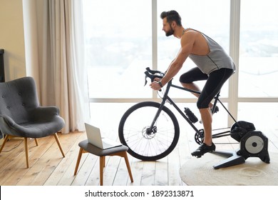 Handsome young man riding stationary exercise bike