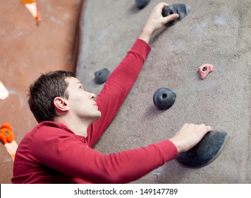 Handsome Young Man Rock Climbing Indoors